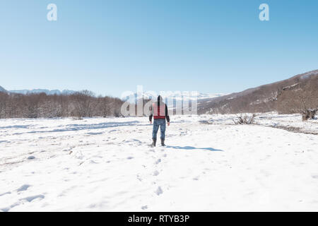 Un homme seul promenades le long du lit congelé d'une rivière de montagne Banque D'Images