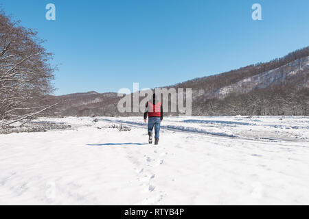 Un homme seul promenades le long du lit congelé d'une rivière de montagne Banque D'Images
