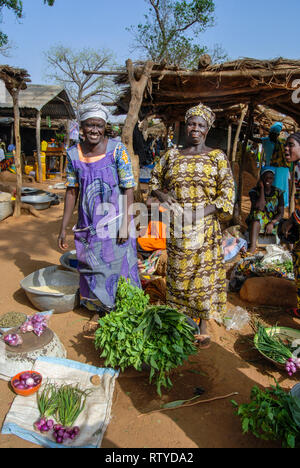 Une belle photo de deux belles femmes ghanéennes portant des vêtements traditionnels pour vendre des légumes et épices à l'échelle locale des produits frais du marché dans village Kongo. Banque D'Images