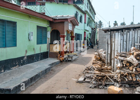 Une photo d'une jeune fille travaillant dans une rue étroite de la ville côtière de Elmina, Ghana, Afrique de l'Ouest. Banque D'Images