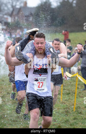 Dorking, UK, 3 mars 2019, maris, amis portent leurs êtres chers pour le sommet de la colline et sur les 380 mètres de course pour une médaille et un fût de bière pendant le UK Femme transportant des championnats qui ont lieu à Dorking, Surry , Royaume-Uni.© Jason Richardson / Alamy Live News. Banque D'Images