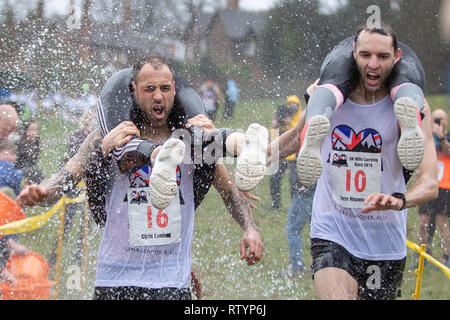 Dorking, UK, 3 mars 2019, maris, amis portent leurs êtres chers pour le sommet de la colline et sur les 380 mètres de course pour une médaille et un fût de bière pendant le UK Femme transportant des championnats qui ont lieu à Dorking, Surry , Royaume-Uni.© Jason Richardson / Alamy Live News. Banque D'Images