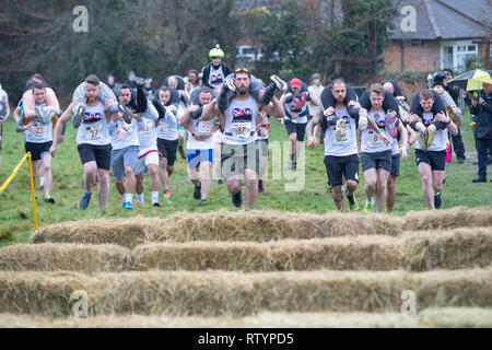 Dorking, UK, 3 mars 2019, maris, amis portent leurs êtres chers pour le sommet de la colline et sur les 380 mètres de course pour une médaille et un fût de bière pendant le UK Femme transportant des championnats qui ont lieu à Dorking, Surry , Royaume-Uni.© Jason Richardson / Alamy Live News. Banque D'Images