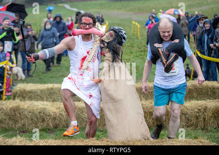 Dorking, UK, 3 mars 2019, maris, amis portent leurs êtres chers pour le sommet de la colline et sur les 380 mètres de course pour une médaille et un fût de bière pendant le UK Femme transportant des championnats qui ont lieu à Dorking, Surry , Royaume-Uni.© Jason Richardson / Alamy Live News. Banque D'Images