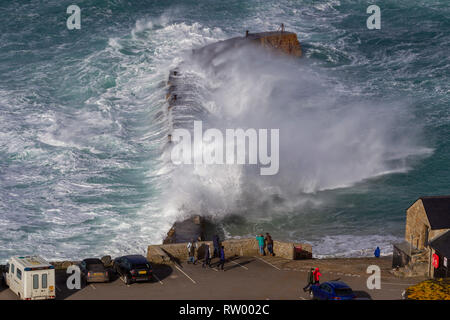 Sennen, Cornwall, UK. Le 3 mars 2019. Des coups de vent et des vagues hautes de 20 pieds lash le granite abruptes de Cornwall. Les cavaliers de l'audace de se faire prendre par des énormes vagues submergeant l'embarcadère. Crédit : Mike Newman/Alamy Live News. Banque D'Images