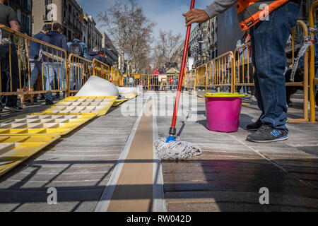 Un opérateur vu travailler au lieu de mémoire dans le centre de Las Ramblas parmi une foule de piétons. Les travaux d'installation sont en cours à l'emplacement mémorial des victimes de l'attaque terroriste dans le quartier de Las Ramblas de Barcelone le 17 août 2017 lorsqu'un van volontairement envahi le centre de la marche qui a fait de nombreux blessés. Banque D'Images