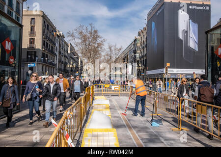 Un opérateur vu travailler au lieu de mémoire dans le centre de Las Ramblas parmi une foule de piétons. Les travaux d'installation sont en cours à l'emplacement mémorial des victimes de l'attaque terroriste dans le quartier de Las Ramblas de Barcelone le 17 août 2017 lorsqu'un van volontairement envahi le centre de la marche qui a fait de nombreux blessés. Banque D'Images