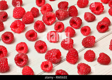 Les framboises fraîchement cueilli du jardin renversé sur les tableaux blancs 24. Banque D'Images