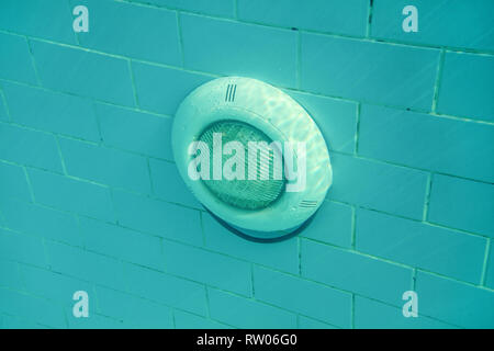 La lumière électrique dans la piscine sur mur carrelage bleu, soleil qui brille d'en haut. Photo sous-marine. Banque D'Images