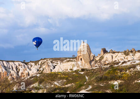 Uchisar, Nevsehir, Turquie Province : une montgolfière vole au-dessus de la cheminée de fées rock formations dans la région historique de la Cappadoce. Banque D'Images