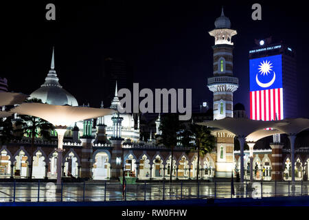 Jamek Masjid Jamek (mosquée) de nuit, drapeau malaisien en arrière-plan. Kuala Lumpur, Malaisie. Banque D'Images