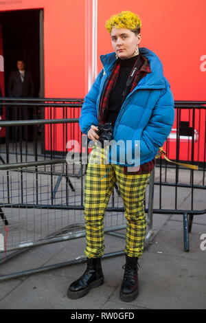 LONDON - 15 février 2019 : . Un invité est vu dans une chemise à carreaux rouge, jaune pantalon à carreaux et une pompe bleue coat lors de la London Fashion Week. Banque D'Images