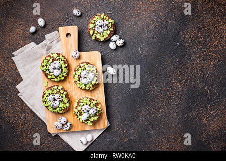 Les cookies de Pâques en forme de nid avec des oeufs Banque D'Images