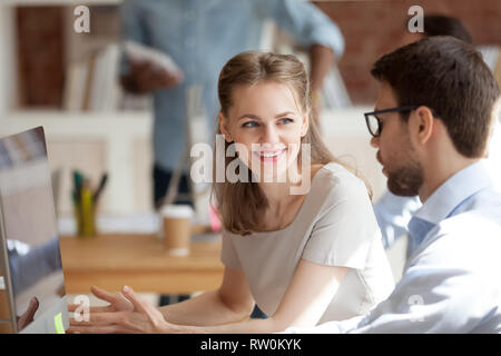 Hommes et femmes millénaire assis à parler de coworking travailler ensemble Banque D'Images