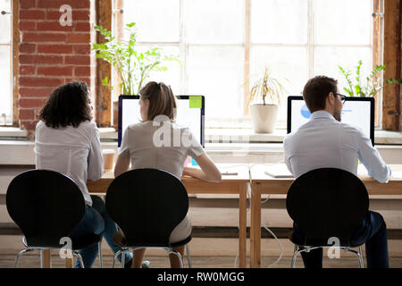 Les femmes et l'homme assis en arrière vue arrière bureau partagé Banque D'Images