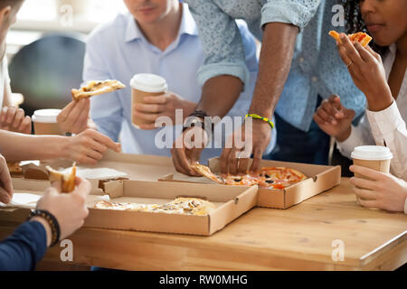 Divers employés eating pizza durant la pause déjeuner Banque D'Images
