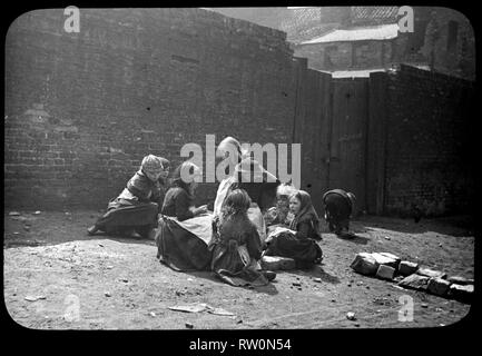 Un groupe d'enfants à jouer dans la dernière partie du 19ème siècle dans le nord-est de l'Angleterre. Lanterne magique, peut-être par Edgar Lee. Banque D'Images