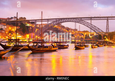 Superbe coucher de soleil sur la rivière Douro avec des bateaux illuminés, Vin Porto skyline et Le Pont Dom Luis I en arrière-plan, Portugal Banque D'Images