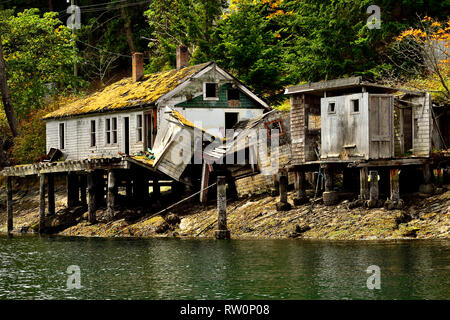 Un bâtiment abandonné le long d'un rivage rocailleux d'une île en mer dans le détroit de Georgia près de l'île de Vancouver en Colombie-Britannique, Canada. Banque D'Images