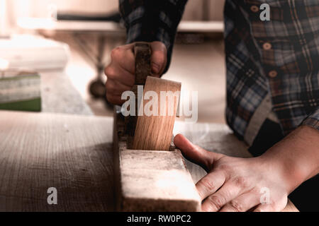 Menuisier travaillant sur le bois à l'aide de vieux bois de charpente ancienne rétro. Contexte de l'atelier. Carpenter workbench. Banque D'Images