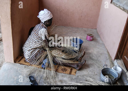 Une photo d'une femme ghanéenne tisser la célèbre et belle décoration du panier Bolga. Banque D'Images