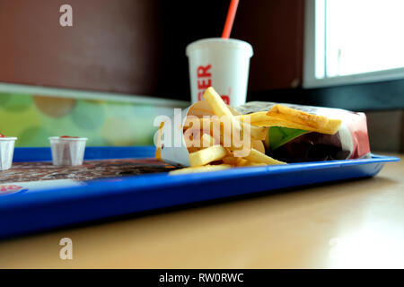 Des frites, un hamburger, sandwich Whopper et un verre dans un Burger King emplacement ; stand et dessus de table à l'intérieur d'un restaurant fast-food Burger King. Banque D'Images