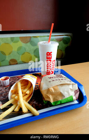 Des frites, un hamburger, sandwich Whopper et un verre dans un Burger King emplacement ; stand et dessus de table à l'intérieur d'un restaurant fast-food Burger King. Banque D'Images