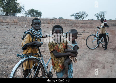 Une belle photo de joyeux et heureux des enfants ghanéens qui posent avec leur vélo lorsqu'ils sont rentré à la maison après une longue journée de travail. Banque D'Images