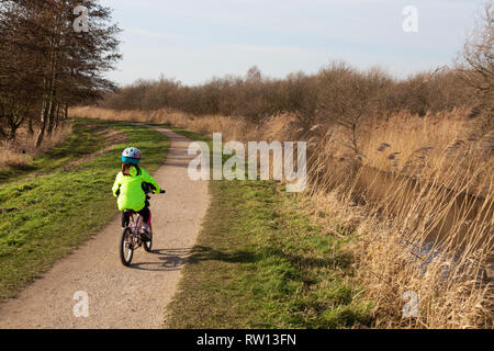 Vélo enfant UK campagne - une jeune fille âgée de 6-7 ans à vélo dans les fens, Cambridgeshire UK Banque D'Images
