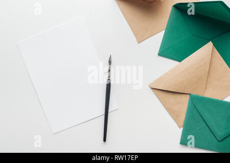 Vue de dessus de la carte vide avec un stylo à encre noire, marron et vert sur fond gris enveloppes Banque D'Images