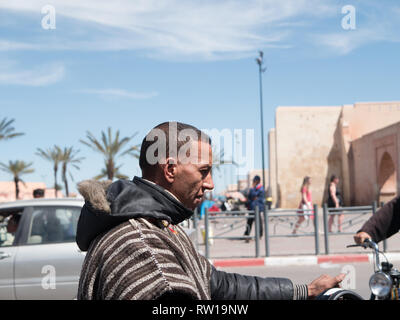 Marrakech, Maroc - 27 mars 2018 : l'homme arabe traditionnel berbère en vêtements équitation une moto sans casque Banque D'Images