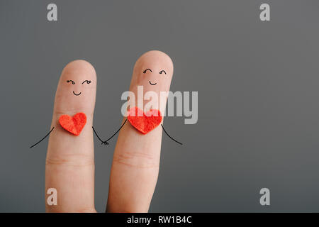 Portrait de l'heureux couple de doigts avec des cœurs holding hands isolé sur gray, concept de Jour de Valentines Banque D'Images