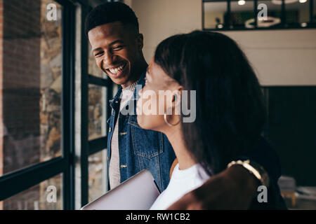 Deux jeunes étudiants traînant sur le campus. Smiling young man standing avec une fille à l'université campus. Banque D'Images