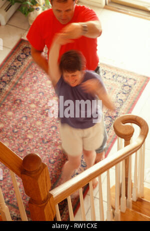 Couple senior dansant au pied des escaliers dans leur maison, USA Vintage Banque D'Images