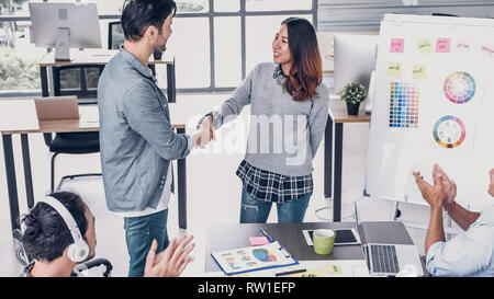 Directeur de la création femme patron de la liaison avec designer et félicitation au sujet d'obtenir la promotion de l'emploi au bureau de création moderne Banque D'Images