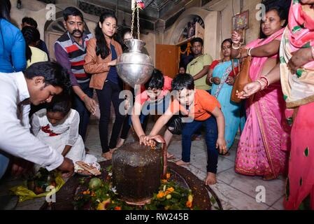 Maha Shivratri. Guwahati, Assam, Inde. Le 4 mars 2019. Les dévots hindous verser de l'eau et lait sur un Lingam, représentant Lord Shiva, dans un temple sur l'ocassion de la 'Maha Shivratri' festival. Crédit : David Talukdar/Alamy Live News Banque D'Images