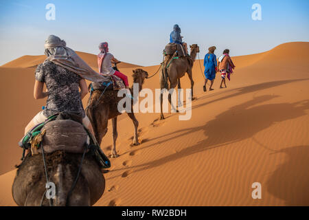 L'ombre des cavaliers camelback étendit à travers les dunes de sable, Merzouga, Maroc Sahara - dunes de l'Erg Chabbi Banque D'Images