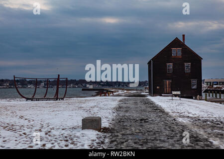 Salem, Massachusetts, États-Unis - 14 septembre 2016 : l'hiver magique coucher du soleil avec un grand bâtiment brun situé à proximité des eaux calmes dans le quartier historique de Salem, Mas Banque D'Images