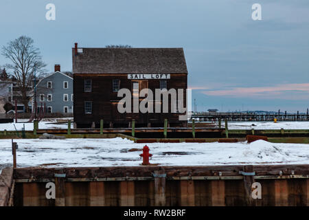 Salem, Massachusetts, États-Unis - 14 septembre 2016 : l'hiver magique coucher du soleil avec un grand bâtiment brun situé à proximité des eaux calmes dans le quartier historique de Salem, Mas Banque D'Images