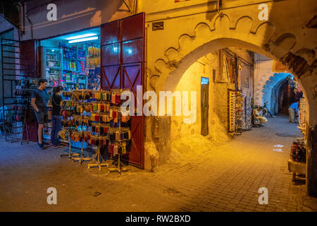 Couple d'un magasin d'achat-avant dans la nuit sur les rues étroites dans la médina de Marrakech, Maroc Banque D'Images