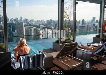12.02.2019, Singapour, République de Singapour, en Asie - les clients de l'hôtel sont à la recherche à la ville tout en bronzant sur la terrasse près de la piscine sur le toit. Banque D'Images