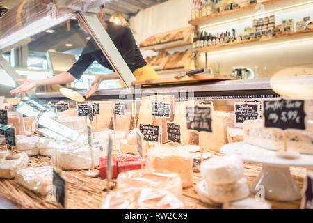 Shop femme greffier fromage dans le tri d'affichage de supermarché Banque D'Images