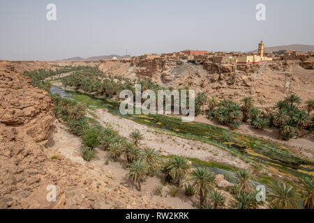 Un cours d'eau apporte la vie et le dynamisme de la zone entourant la ville d'Akka N'Ait Sidi, Province de Tata, Maroc, Souss-Massa. Akka N'Ait Sidi Banque D'Images