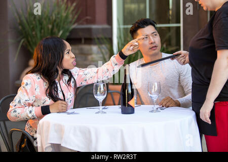 Couple sur une date en colère contre une serveuse dans un restaurant en plein air. Ils sont mécontents et insatisfaits de la service à la clientèle ou la nourriture dans le café. E Banque D'Images