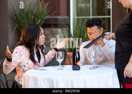 Couple sur une date en colère contre une serveuse dans un restaurant en plein air. Ils sont mécontents et insatisfaits de la service à la clientèle ou la nourriture dans le café. E Banque D'Images