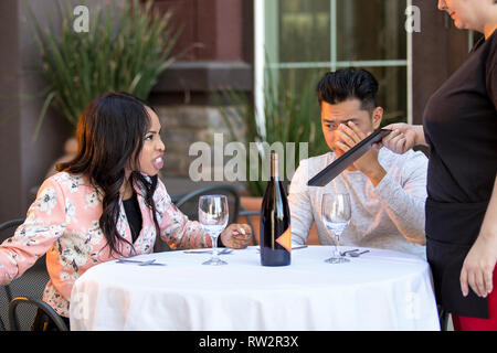 Couple sur une date en colère contre une serveuse dans un restaurant en plein air. Ils sont mécontents et insatisfaits de la service à la clientèle ou la nourriture dans le café. E Banque D'Images