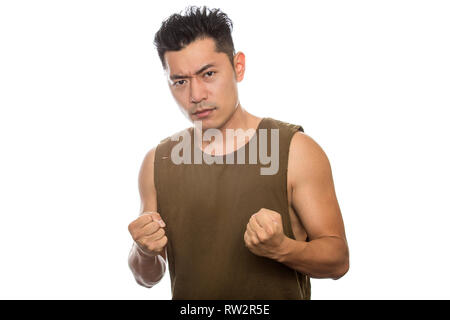 Athletic homme asiatique avec des t-shirt déchiré sur un fond blanc. Il est l'affichage des expressions ou des gestes de colère. Le beau chinois ou Banque D'Images