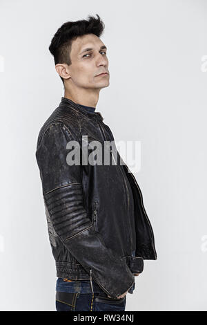 L'homme hautain en blouson de cuir sur fond blanc, photo en studio, photo verticale Banque D'Images