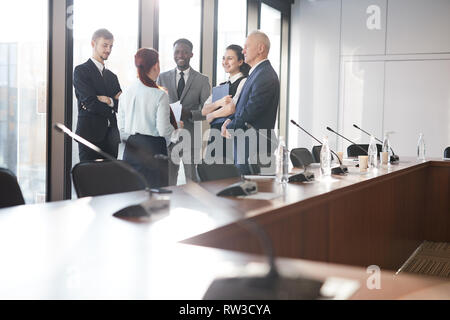 Multi-ethnic group of business people standing par fenêtre dans Office et communiquer, copy space Banque D'Images