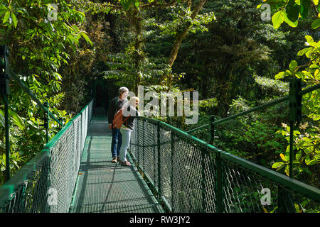 Les touristes sur pont suspendu à pied à pied en forêt nuageuse de Monteverde, Costa Rica, Amérique Centrale Banque D'Images